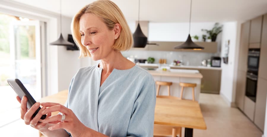 Homeowner with smartphone in a room filled with sunlight